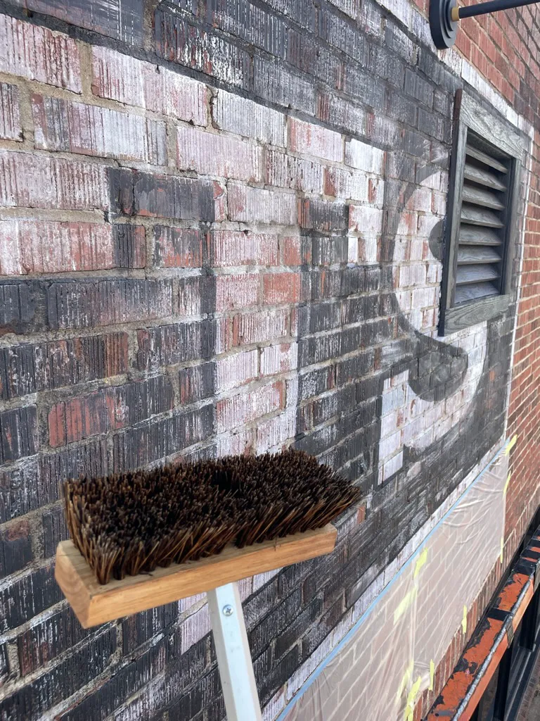 ghost sign - removing the resist with a scrub brush - Florence Alabama 